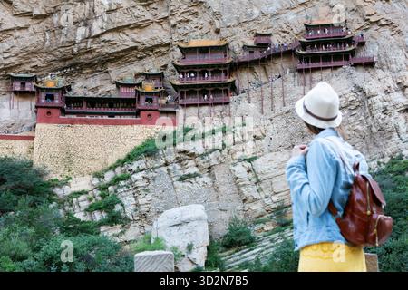 Junger Tourist, der den hängenden Tempel oder das hängende Kloster in der Nähe von Datong in der Provinz Shanxi, China, sucht. Stockfoto