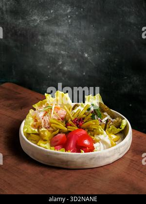 Verschiedene Snacks aus fermentiertem Kohl, Gurken und Tomaten, grüne Bohnen. Dekorierte Preiselbeere. Fermentiertes gesundes Lebensmittelkonzept. Eingelegte Gurken, marinierte Tomaten Vertical. Stockfoto