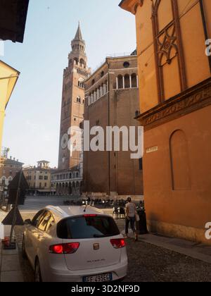 Cremona, Italien 14. August 2025 Weißer Sitz Altea parkt in einer engen Straße, die zur Piazza del Comune mit der Kathedrale von Cremona und dem Glockenturm von Torrazzo führt Stockfoto