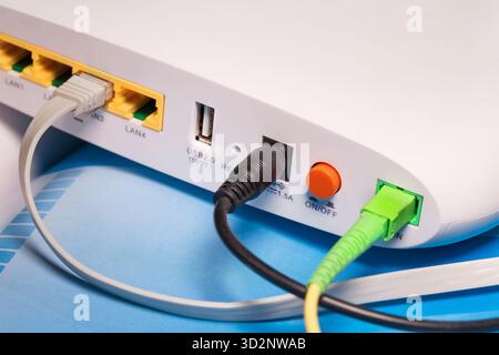 GPON-Teilnehmerterminal mit Anschluss an ein Glasfasernetzwerk und lan-Kabel auf .Rückansicht Stockfoto
