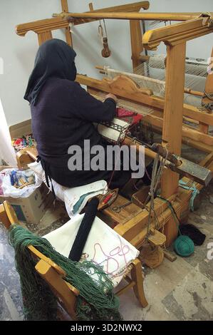 Traditioneller Webhandwerker bei Loom, der bunte Textilien kreiert Stockfoto