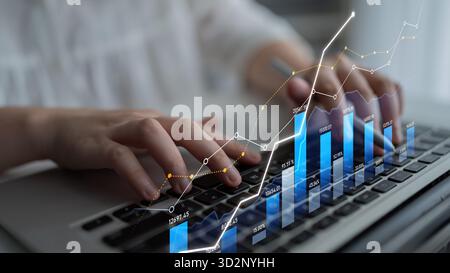 Ein Geschäftsmann arbeitet mit Finanzdaten auf einem Notebook. Die Abbildung zeigt Diagramme und Diagramme, die Wachstumstrends in einem modernen Arbeitsbereich darstellen. S Stockfoto