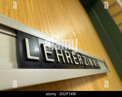 Nahaufnahme eines alten Lehrerbüros im deutschen Lehrerzimmer-Schild an einer hölzernen Schultür. Symbol für Bildung, Autorität, Lernumgebung und die Stockfoto