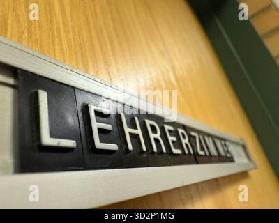 Nahaufnahme eines alten Lehrerbüros im deutschen Lehrerzimmer-Schild an einer hölzernen Schultür. Symbol für Bildung, Autorität, Lernumgebung und die Stockfoto