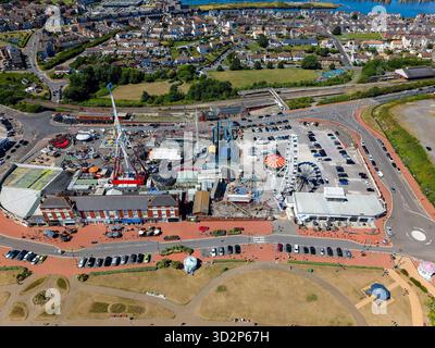Barry, Wales - 30.2025: Drohnenaufnahme mit den Fahrgeschäften, dem Bahnhof und der Küste von Barry Island, Großbritannien Stockfoto