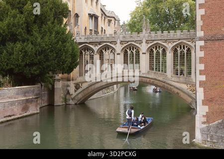 Besucher, die eine Punt-Tour auf dem Fluss Cam unter der Seufzerbrücke im St John's College, Cambridge, Unternehmen Stockfoto