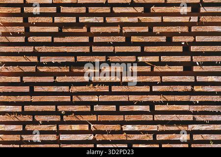 Stapel Holzbauplanken, die zum Trocknen angeordnet sind. Stapel von Holzbrettern, die im Freien in ordentlichen Reihen gelagert werden. Industrielles Muster. Stockfoto