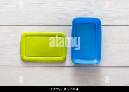 Leere Plastik-Lunchboxen auf weißem Holz, Draufsicht Stockfoto