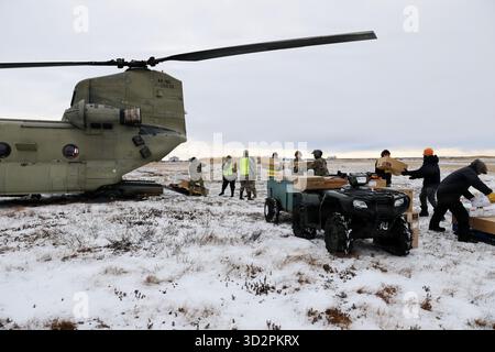 Nunapitchuk, Vereinigte Staaten von Amerika. 28. Oktober 2025. Soldaten und Freiwillige der Nationalgarde der Alaska Army entladen Hilfsgüter von einem CH-47 Chinook Hubschrauber während der Notfallreaktion für die Opfer des Taifuns Halong, 28. Oktober 2025 in Nunapitchuk, Alaska. Der Sturm verdrängte mindestens 1500 Ureinwohner und ließ Dörfer in Trümmern zurück. Quelle: PFC. Azavyon McFarland/Alaska National Guard Photo/Alamy Live News Stockfoto