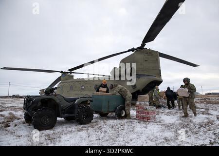 Nunapitchuk, Vereinigte Staaten von Amerika. 28. Oktober 2025. Soldaten und Freiwillige der Nationalgarde der Alaska Army entladen Hilfsgüter von einem CH-47 Chinook Hubschrauber während der Notfallreaktion für die Opfer des Taifuns Halong, 28. Oktober 2025 in Nunapitchuk, Alaska. Der Sturm verdrängte mindestens 1500 Ureinwohner und ließ Dörfer in Trümmern zurück. Quelle: PFC. Azavyon McFarland/Alaska National Guard Photo/Alamy Live News Stockfoto