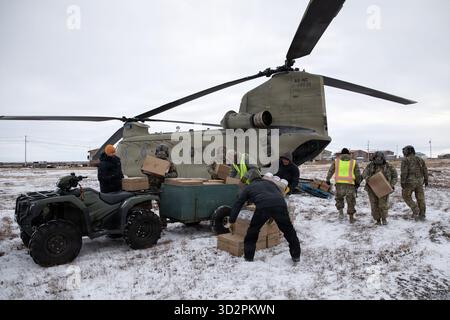 Nunapitchuk, Vereinigte Staaten von Amerika. 28. Oktober 2025. Soldaten und Freiwillige der Nationalgarde der Alaska Army entladen Hilfsgüter von einem CH-47 Chinook Hubschrauber während der Notfallreaktion für die Opfer des Taifuns Halong, 28. Oktober 2025 in Nunapitchuk, Alaska. Der Sturm verdrängte mindestens 1500 Ureinwohner und ließ Dörfer in Trümmern zurück. Quelle: PFC. Azavyon McFarland/Alaska National Guard Photo/Alamy Live News Stockfoto