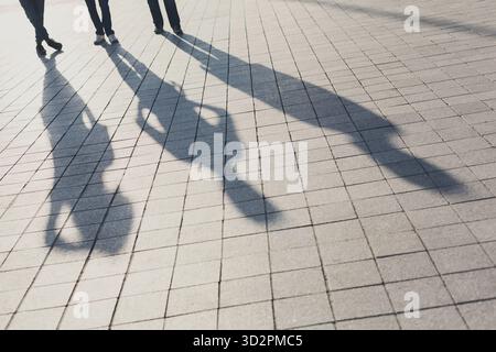 Schatten von drei Freunden auf dem Bürgersteig Stockfoto