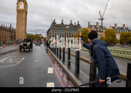 London, Großbritannien. November 2025. Ein Zuschauer fotografiert ein Veteranenauto auf der Westminster Bridge. Der jährlich stattfindende RAC London to Brighton Veteran Car Run, der 1896 gegründet wurde, ist das am längsten laufende Motorrennen der Welt. Es ist offen für Fahrzeuge, einschließlich Fahrräder und Motorräder, die vor 1905 gebaut wurden, und zeigt Fahrzeuge, die älter als 120 Jahre sind. Die Teilnehmer beginnen jeden ersten Sonntag im November um 7:00 Uhr im Hyde Park, London, und Unternehmen eine nicht wettbewerbsfähige 60 km lange Reise zum Madeira Drive Brighton, East Sussex. Quelle: SOPA Images Limited/Alamy Live News Stockfoto