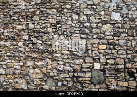 Jahrhundertealte Steinmauer – rustikaler und verwitterter Hintergrund Stockfoto