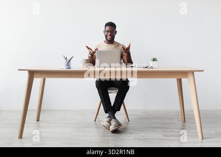 Millennial Black man im Home Office genießt Fernarbeit und Videoanrufe Stockfoto