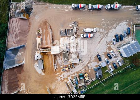 Betonwerk mit Silos, Mischwagen und Rohmateriallagerung. Zementfabrik, Luftaufnahme. Produktion und Lieferung von Beton und Baumaterialien Stockfoto