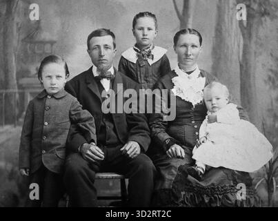 Stoisch aussehende Familie posiert für ein Porträt, ca. 1880er Jahre Stockfoto