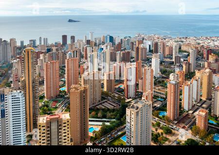 Panoramablick auf die moderne Skyline von Benidorm mit Hochhäusern, Strandresorts und dem glitzernden Mittelmeer. Beliebtes Touristenziel in der Region Alicante in Spanien. Stockfoto
