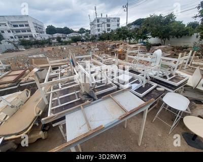 Chaotische Deponie mit großen Häufern verlassener und kaputter Möbel. Dieser einsame Schrottplatz aus beschädigtem Holz und Metallabfällen, einschließlich entsorgtem weiß Stockfoto
