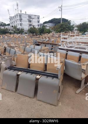 Alte, verlassene Sitzreihe erinnert an das Gefühl der Einsamkeit auf einem Schrottplatz im Freien. Verwitterte öffentliche Kunststoff- und Metallmöbel warten auf die Disposition Stockfoto