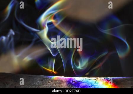 Mystische bunte Rauchwolken in abstrakten Mustern vor dunklem Hintergrund. Dieser faszinierende Dampf offenbart ein lebendiges Regenbogenspektrum, kreativ Stockfoto