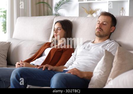 Ein wütendes Paar, das sich ignoriert, auf einem Sofa zu Hause auf einer Couch sitzt Stockfoto