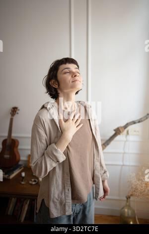 Junge Frau, die Stressabbau übt, Atemübungen zur Beruhigung macht, Hand auf Brust hält. Stockfoto