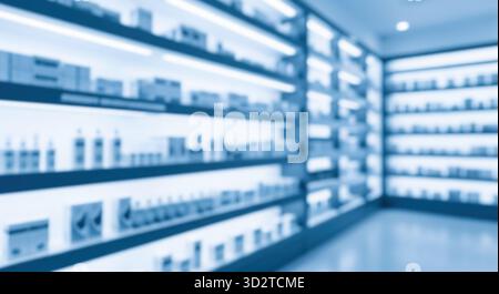 Verschwommener Hintergrund der modernen Apotheke mit beleuchteten Regalen, futuristischer Drogeriemarkt oder Kosmetikgeschäft Innenraum, abstrakte High-Tech Medizin und Gesundheit Stockfoto