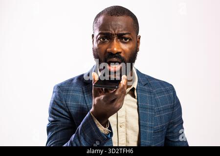 Verärgerte den afrikanischen Geschäftsmann mit Bart, indem er während eines Telefongesprächs Sorgen und Spannungen ausdrückt. Stockfoto