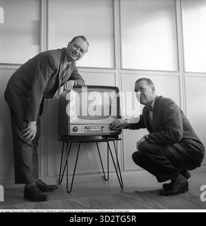 Fernsehgerät in den 1950ern Ein frühes Fernsehgerät von Philips im historischen Design und auf einem Ständer aus Metallbeinen, das nur Fernsehsendungen in Schwarzweiß wiedergeben kann. Mit den Knöpfen an der Vorderseite steuern Sie Bild und Ton. 1956 Svahn Stockfoto