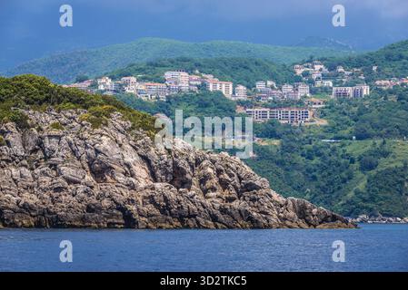 Felsigen Ufer der Adria Küste in der Nähe von Budva in Montenegro. Prijevor Stadt auf Hintergrund Stockfoto