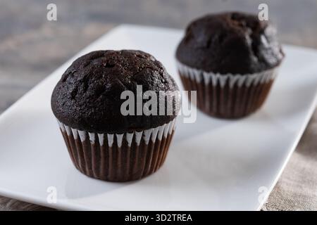 Schokoladenmuffins auf Holztisch Stockfoto