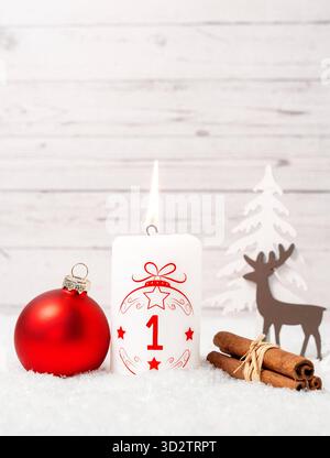 Bayern, Deutschland - 29. Oktober 2025: Die erste Adventskerze brennt zum ersten Adventstag. Eine weiße Kerze mit rotem Schriftzug und der Nummer 1 vor Weihnachtsdekoration *** erste Adventskerze zum ersten Adventsbrand. Eine weiße Kerze mit roter Schrift und mit der Zahl 1 vor weihnachtlicher Dekoration Stockfoto