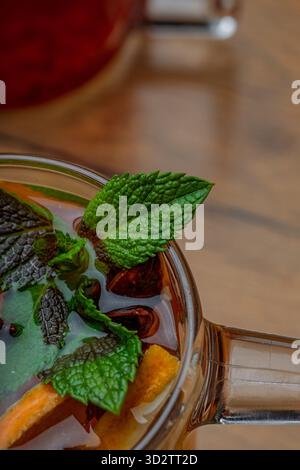 Herbsttee mit Gewürzen und Minze in einem transparenten Glas Stockfoto