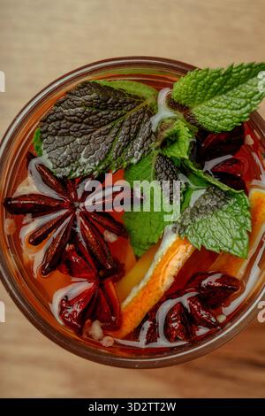 Herbsttee mit Gewürzen und Minze in einem transparenten Glas Stockfoto