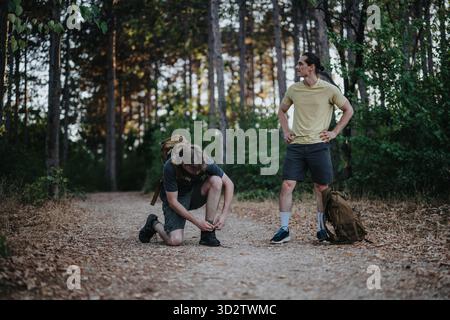 Zwei Wanderer auf einem Waldweg bereiten Ausrüstung während einer Wanderung im Freien vor Stockfoto