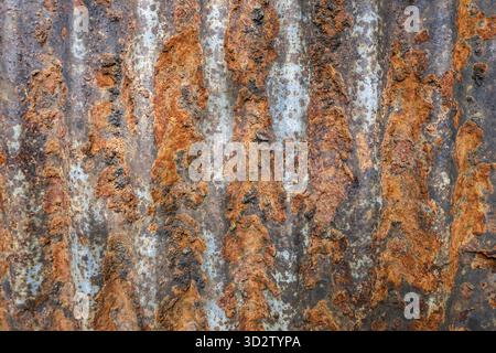 Rostiger gewellter Metalloberflächentexturhintergrund. Altes verwittertes Eisenblech mit abstraktem Grunge-Muster. Detaillierte Zersetzung und Korrosion erzeugen Rostbildung Stockfoto