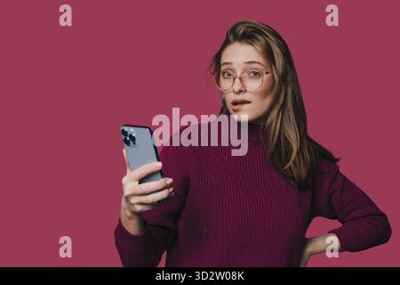 Staunende Frau, die erforscht, Frau in Lila untersucht Botschaft Stockfoto