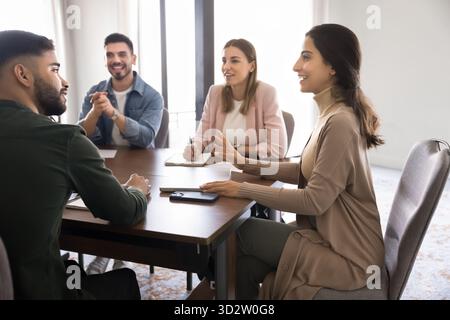 Eine Gruppe von Fachleuten versammelte sich um einen Besprechungstisch in einem modernen Büro Stockfoto