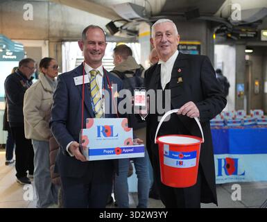 Sprecher des House of Commons, Sir Lindsay Hoyle (rechts), zusammen mit dem Freiwilligen Christopher Leader, der Mohnblumen für den Royal British Legion Poppy Appeal verkauft, an der U-Bahn-Station Westminster in London. Bilddatum: Montag, 3. November 2025. Stockfoto