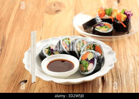 Koreanischer gerollter Gimbap, aus Reis, Karotten, Wurst, Krabbenstiel, Eier, Fischkuchen und mit Seetang-Laver gewickelt. Serviert mit würziger Dipping Sauce. Ein Stockfoto