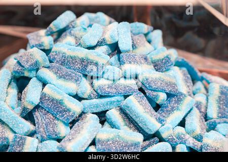 Ein Haufen blauer Gelee-Bonbons, bestreut mit Puderzucker. Stockfoto