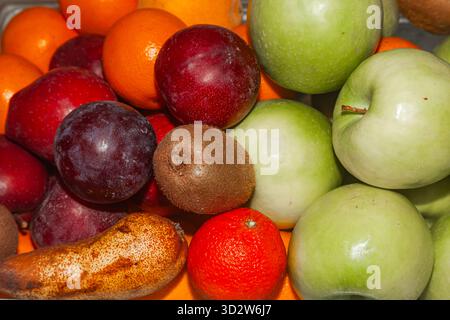 Fruchthintergrund von Äpfeln, Pflaumen, Birnen und Orangen Stockfoto