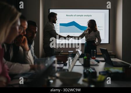 Geschäftspartner händigen nach der Präsentation während eines Teammeetings mit dokumentierten Ergebnissen in einem Konferenzraum Stockfoto