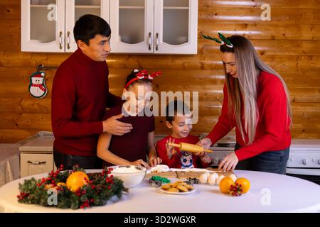 Die Familie bereitet gerne Weihnachtskekse zusammen in der Küche vor Stockfoto