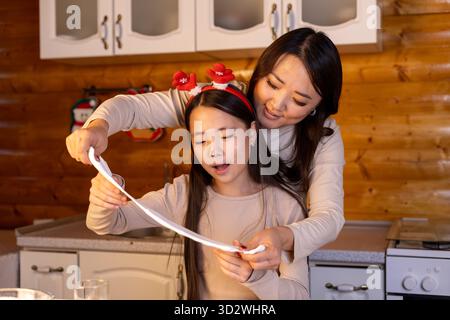 Mutter und Tochter machen fröhlich Weihnachtsgeschenke zusammen in der Küche Stockfoto