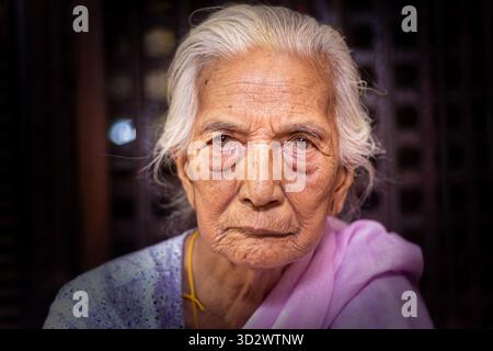 Der Blick der nepalesischen älteren Frau auf den Goldenen Tempel in Lalitpur Stockfoto