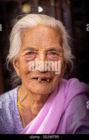 Nepalesische ältere Frau mit einem dankbaren Lächeln im Golden Temple, Lalitpur Stockfoto