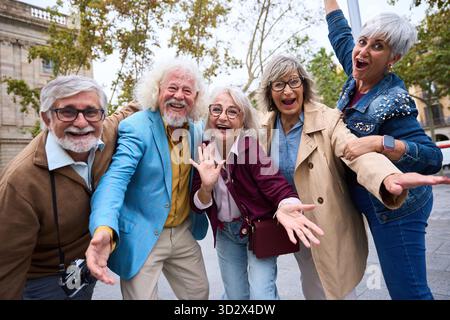 Gruppe fröhlicher Senioren, die gemeinsam Stadtreisen genießen Stockfoto