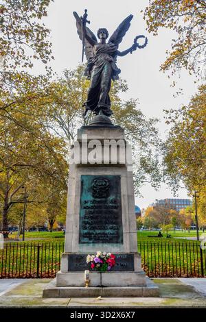 Das Kriegsdenkmal in Shepherds Bush Green in London, Großbritannien im Herbst mit goldbraunen Blättern auf den Bäumen Stockfoto